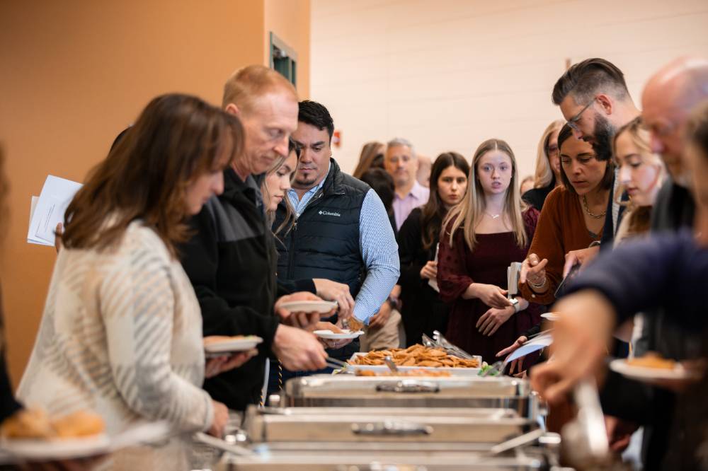 Ceremony attendees get food from buffet